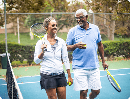 Smiling couple holding a tennis ball and a racket