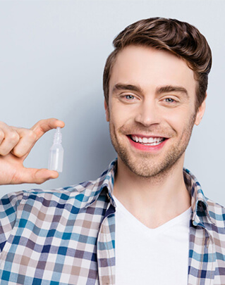 Man smiling holding a lipiflow eye drops at Eye Consultants