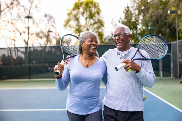 Older couple playing tennis together